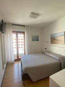 a bedroom with a large bed and a window at Hotel Marea in Grado