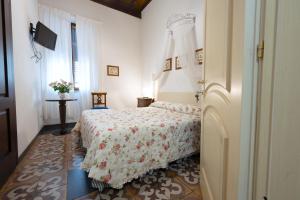 a bedroom with a bed with a floral bedspread and a window at Affittacamere Le camerine di Silvia 2 in Siena