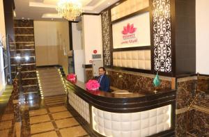 a man standing at a counter in a hotel lobby at الضيافة ريجنسي - Al Deyafah Regency in Khamis Mushayt