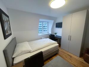 um pequeno quarto com uma cama e uma janela em SCHNYDER'S HOME - Studio_1 em Rapperswil-Jona