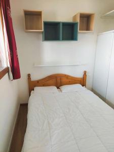 Cette petite chambre comprend un lit avec des draps blancs. dans l'établissement Super Besse 5/6 pers. Vue sur les monts du cantal, à Besse-et-Saint-Anastaise