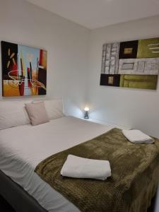 1 dormitorio con 1 cama con 2 toallas en Collins St, Southern Cross, 2 bd, PARKING, FREE WIFI, en Melbourne