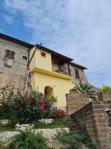 Casa amarilla con balcón y algunas flores en Casa romantica in un borgo antico in Sabina, en Cicignano