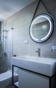 La salle de bains est pourvue d'un lavabo blanc et d'un miroir. dans l'établissement Hermosa townhouse boca paraíso, à Boca Chica