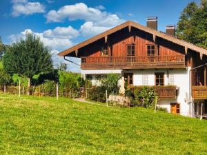 una casa de madera con un campo verde delante de ella en Fritzis Alpenidyll „Sommertraum & Winterromantik”, en Samerberg