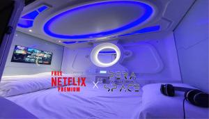 a room with a bed and a tv in it at PERA SPACE Capsule Hotel in Phuket Town