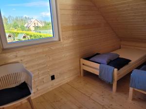 um pequeno quarto com uma cama e uma janela em Domek letniskowy Młyn2 em Karwieńskie Błoto Pierwsze