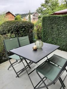 una mesa y dos sillas con un tazón. en Appartement avec terrasse centre samoens, en Samoëns