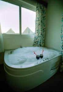 uma banheira num quarto com uma janela em Pyramid Edge Hotel no Cairo