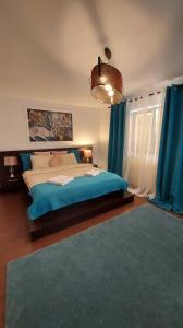 una camera da letto con un grande letto con lenzuola blu e tende blu di Ambiennt a Bucarest