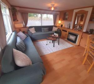 sala de estar con sofá azul y mesa en Delightful tiny home in the middle of nature., 