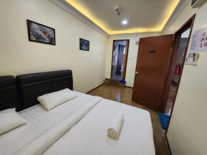 a bedroom with a large bed with white sheets at LTH (Little Turtle's Home) in Semporna