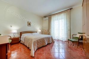 1 dormitorio con 1 cama, 1 silla y 1 ventana en Locazione turistica Lorusso, en Andria