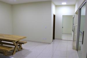 Pokój z drewnianym stołem i schodami w obiekcie Sobrado espaçoso com piscina com ar na suite w mieście Chapada dos Guimarães