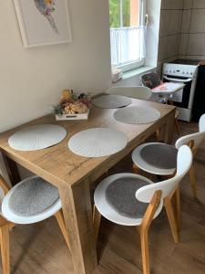 un tavolo in legno con 4 sedie intorno in cucina di APARTMENT OWL a Kořenov
