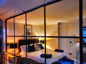 a room with a bed with a glass wall at Cocoa Isabella - River fronted with secure parking in York