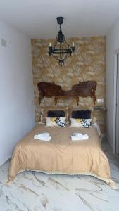 um quarto com uma cama grande e um lustre em Santa Marta em Martos