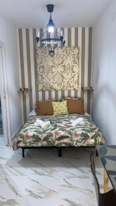 Ce lit se trouve dans un dortoir doté d'un lustre. dans l'établissement San Amador, à Martos