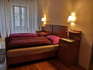 een slaapkamer met een bed met rode lakens en een raam bij Swiss House Apartments in Slavonice