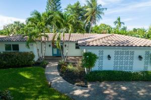 a white house with palm trees and a driveway at Moana Beach Cottage in Fort Lauderdale