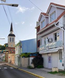 a street with a building and a church at Le Toutapied , Sainte-Anne, appartement en plein centre in Sainte-Anne