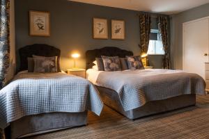 um quarto com 2 camas e uma janela em Chester House Hotel em Bourton on the Water