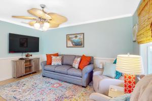 a living room with a couch and a tv at Sunset Breeze #4 in Dauphin Island