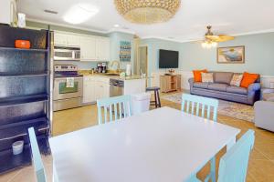 uma cozinha e sala de estar com uma mesa e um sofá em Sunset Breeze #4 em Dauphin Island