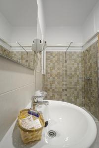 - un lavabo dans la salle de bains avec un panier dans l'établissement Hotel Montemar, à La Marina
