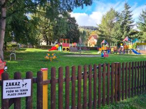 a park with a wooden fence and a playground at Apartament u Maryśki in Karpacz