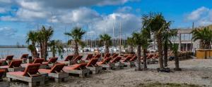 a row of chairs sitting on a beach near the water at Adventures with friends & family stay only or learn to set sail with skipper Casey in Medemblik