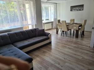 a living room with a couch and a dining room at Apartament u Maryśki in Karpacz
