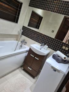 a bathroom with a sink and a tub and a toilet at Apartament u Maryśki in Karpacz