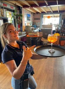 a woman sitting at a bar with a drink on a table at Adventures with friends & family stay only or learn to set sail with skipper Casey in Medemblik