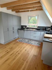 uma cozinha com armários brancos e piso em madeira em Ruheoase mitten in der Natur em Wilhelmsdorf