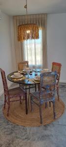uma sala de jantar com uma mesa de vidro e cadeiras em Flamencos Rosados em José Ignacio
