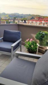 a balcony with a blue chair and potted plants at B&B Le Albarelle in Alba +49 photos