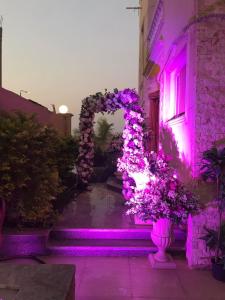 dom z fioletowymi światłami na dziedzińcu w obiekcie Trio Villa with coverable private pool in compound near Mall of Egypt w mieście Sheikh Zayed