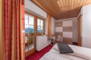 a bedroom with a bed and a desk and a window at Haus Steirerland in Schladming