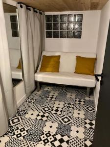 Cette petite chambre dispose d'un canapé et de carrelage. dans l'établissement Appartement FACE MER accès direct plage, à Houlgate 10 autres photos