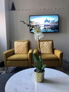 - un salon avec deux chaises et une table fleurie dans l'établissement Appartement FACE MER accès direct plage, à Houlgate