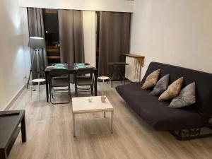 un salon avec un canapé noir et une table dans l'établissement F3 au cœur du centre de Metz, à Metz