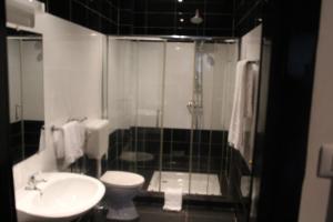een badkamer met een wastafel, een toilet en een douche bij A & A TERANGA in Somone