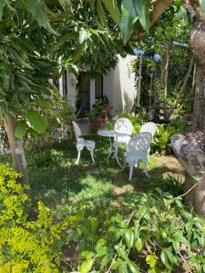 two white chairs and a table in a yard at 2 Bedroom Apartment in Pereybere with Private Balcony in Pereybere
