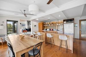 a kitchen and dining room with a wooden table and chairs at Moggs Magic in Aireys Inlet