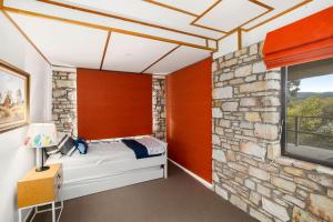 a bedroom with a stone wall at Moggs Magic in Aireys Inlet