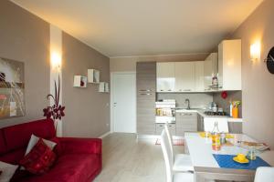 Il comprend un salon avec un canapé rouge et une cuisine. dans l'établissement Italian Vacation Homes - Gemini, à Tavernola Bergamasca
