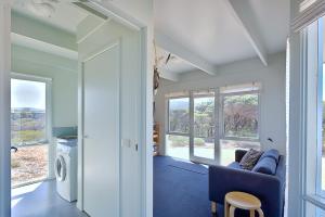 a living room with a blue couch and some windows at Moggs View in Aireys Inlet
