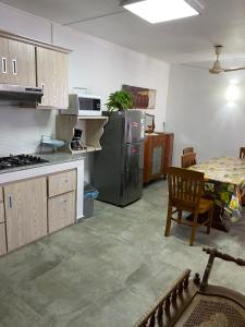une cuisine avec un réfrigérateur en acier inoxydable et une table dans l'établissement 2 Bedroom Apartment in Pereybere with Private Balcony, à Pereybere