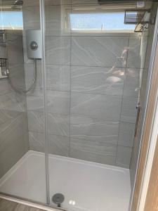 a shower with a glass door in a bathroom at 265 Belle Aire, Modern Property in Hemsby